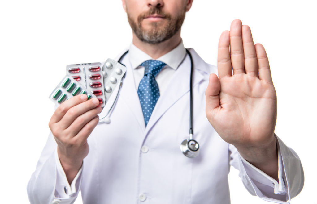 Médico com cartela de remédios na mão