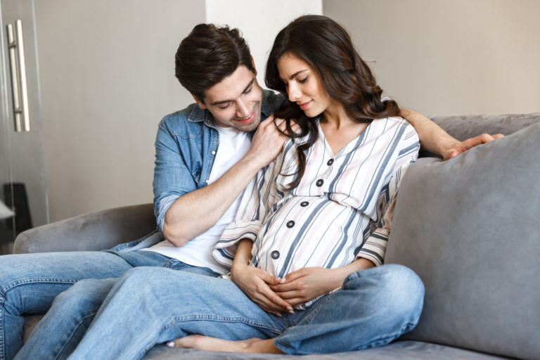 Homem observando a barriga de gravidez da esposa