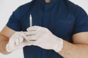 Médico com seringa de preenchimento peniano