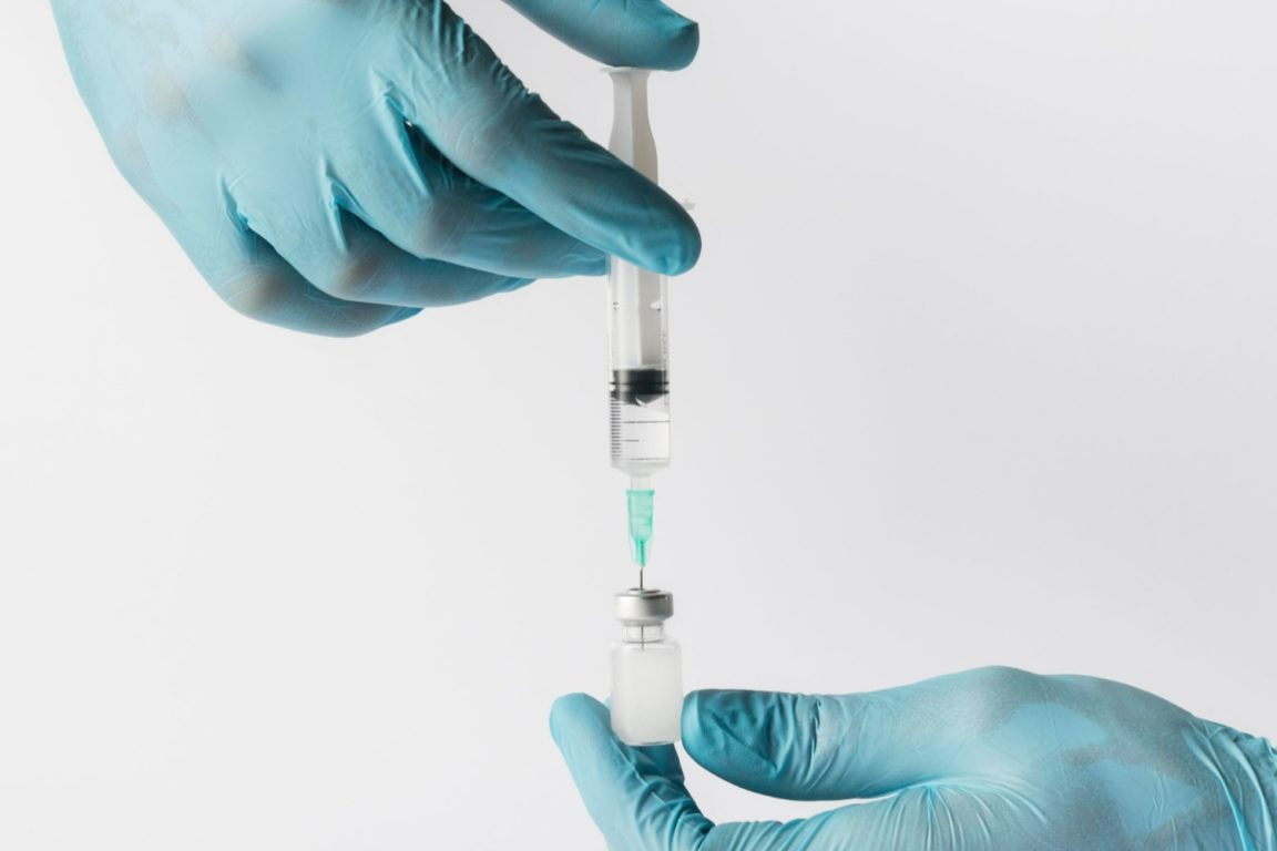 Mãos do médico com luvas manipulam uma seringa para aplicação de Urofill. Veja como funciona