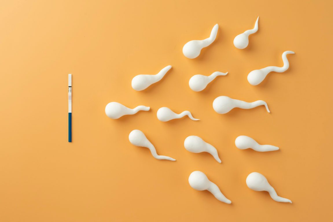 Espermatozoides sobre a mesa indo em direção a um teste de gravidez, para falar sobre varicocele e infertilidade masculina
