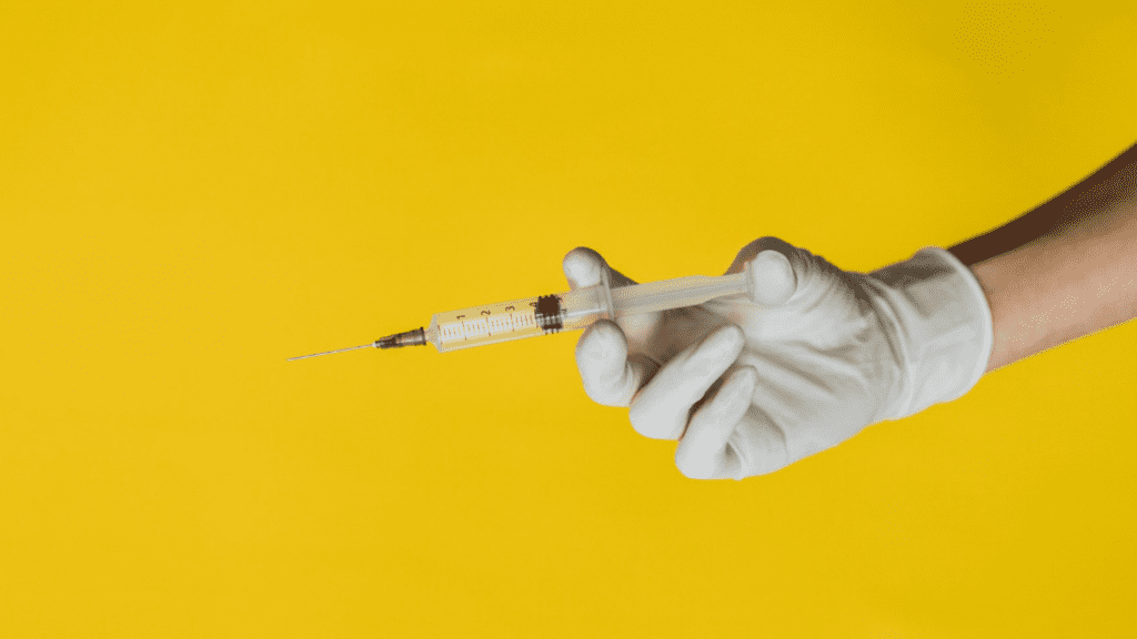 Mão do médico com luva, segurando uma seringa para aplicação de Urofill, mitos e verdades