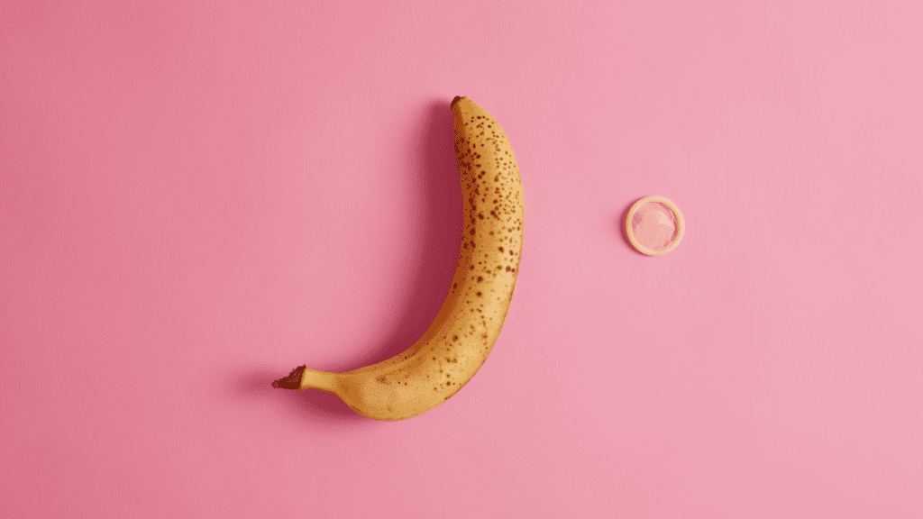 Banana torta sobre fundo rosa, para falar sobre fatores de risco e prevenção de Peyronie