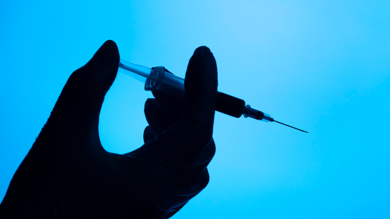 Profissional com luvas e seringa na mão, para aplicar urofill