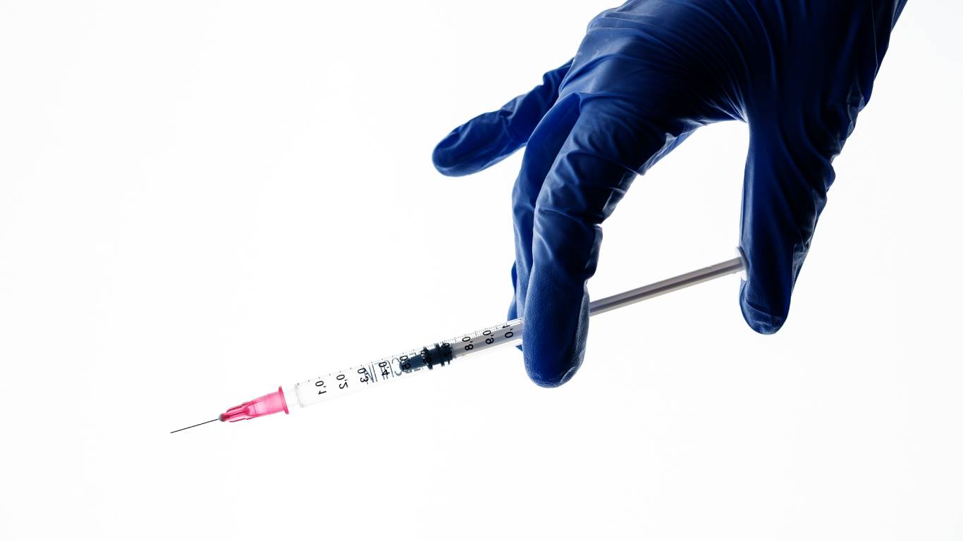 Médico com luvas e seringa para preenchimento peniano com ácido hialurônico