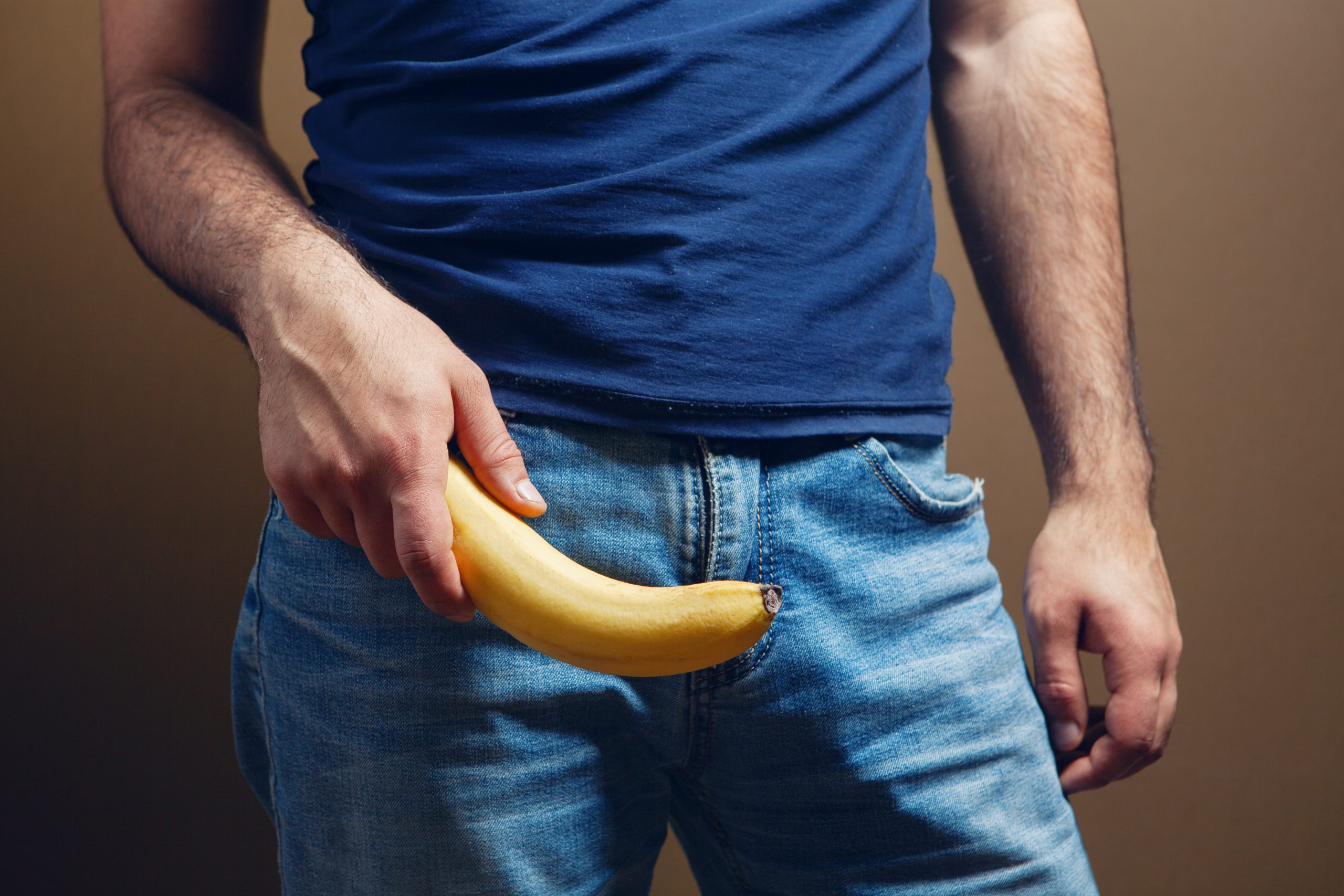 Homem com uma banana na mão, pensando se o engrossamento peniano muda a ereção